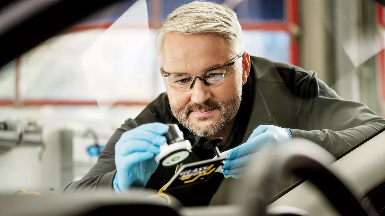 Carglass Monteur repariert Steinschlag