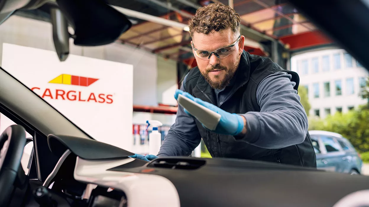 Carglass Monteur reinigt die Windschutzscheibe