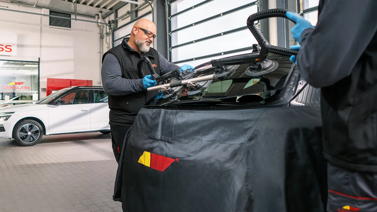 Monteur tauscht Heckscheibe